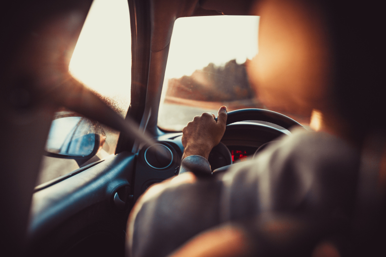 a guy behind the wheel of his car driving