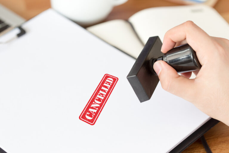 a person stamping the word "cancelled" on a document