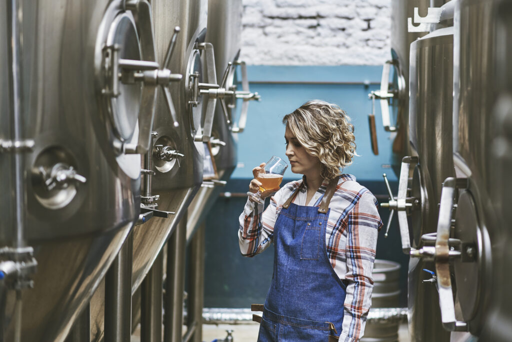 hispanic female craft brewer examining beer