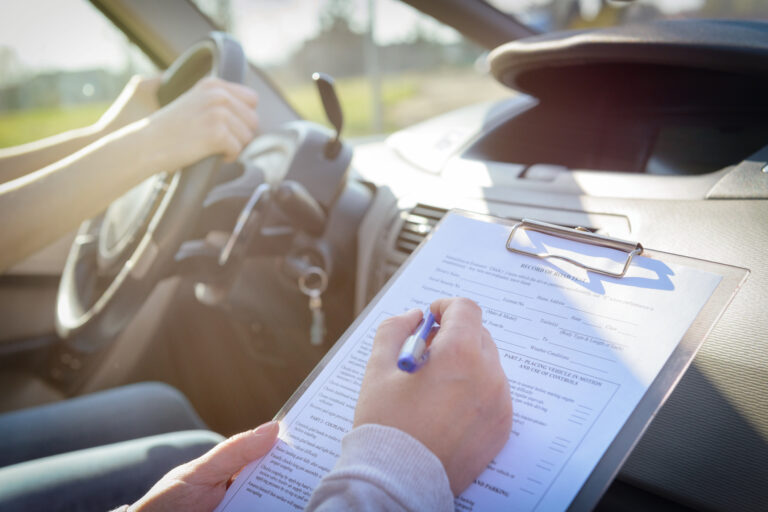 a driver examiner filling out paper for a road test
